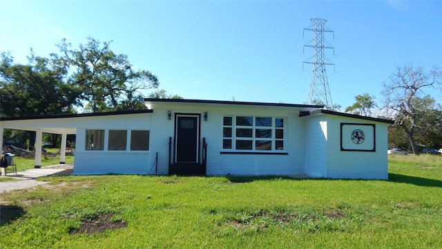 view of front facade with a front yard and a carport