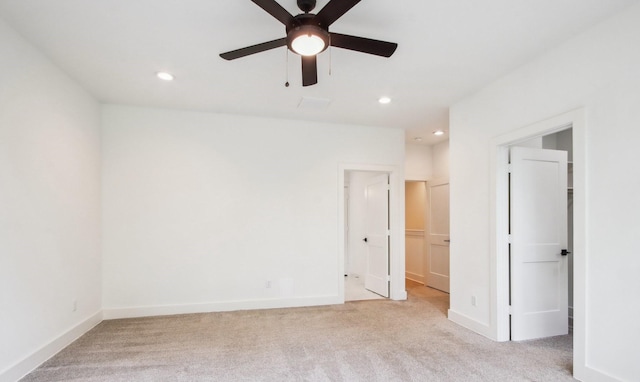 unfurnished bedroom with recessed lighting, light carpet, baseboards, and ensuite bathroom