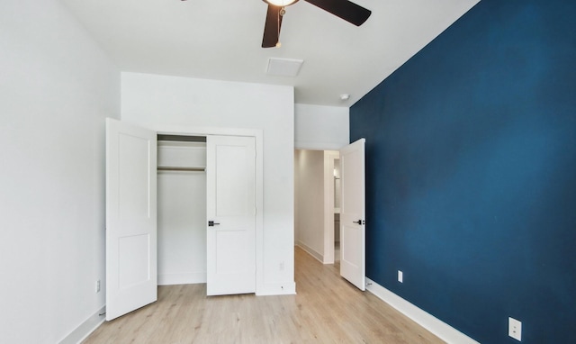 unfurnished bedroom featuring wood finished floors, a ceiling fan, visible vents, baseboards, and a closet