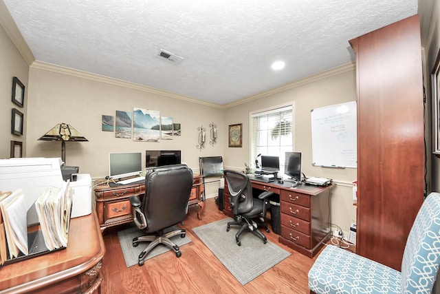 office with visible vents, a textured ceiling, and wood finished floors