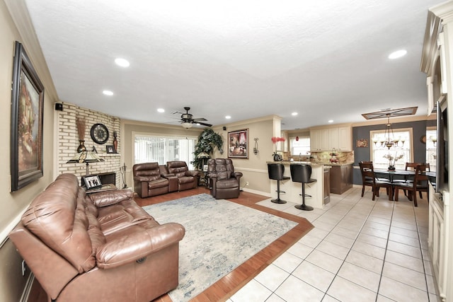 living room with light tile patterned floors, ceiling fan with notable chandelier, a textured ceiling, and recessed lighting