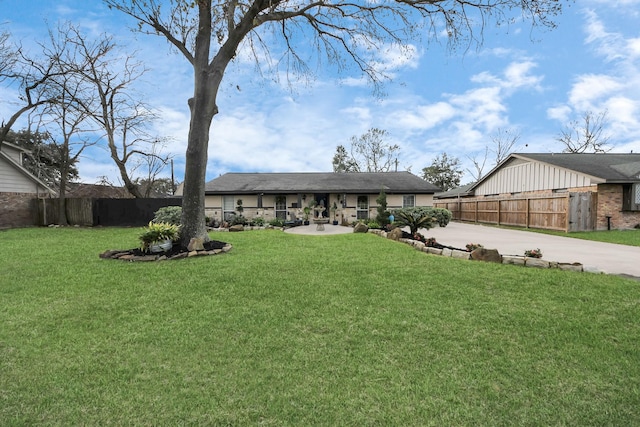 view of front of home with fence, a front lawn, and a patio