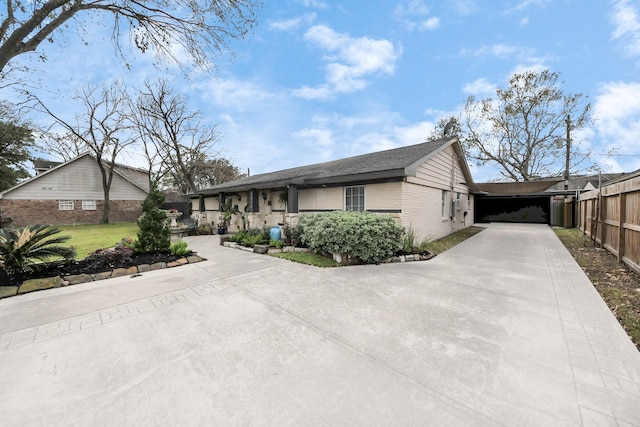 view of front facade with a garage, concrete driveway, brick siding, and fence