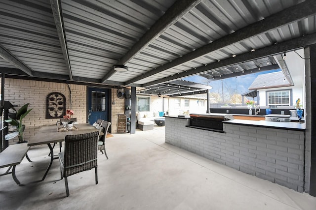 view of patio with a grill, outdoor dining area, a sink, and area for grilling