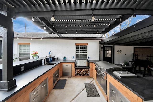 view of patio / terrace with exterior kitchen, a pergola, and a sink