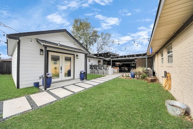 rear view of house with a patio, a yard, french doors, and fence