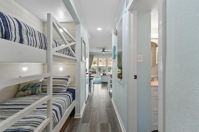 bedroom featuring a textured wall, dark wood-type flooring, and baseboards