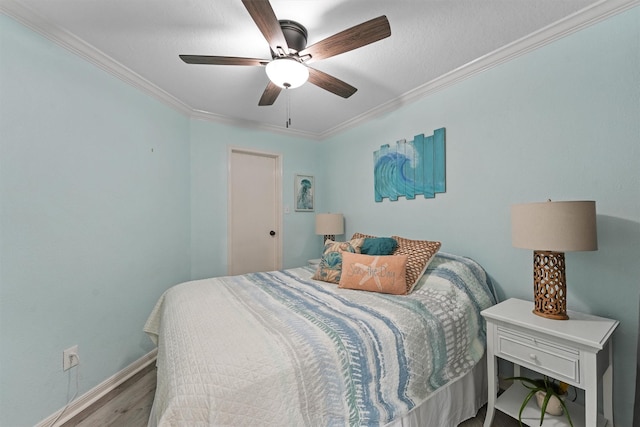 bedroom with ceiling fan, baseboards, crown molding, and wood finished floors