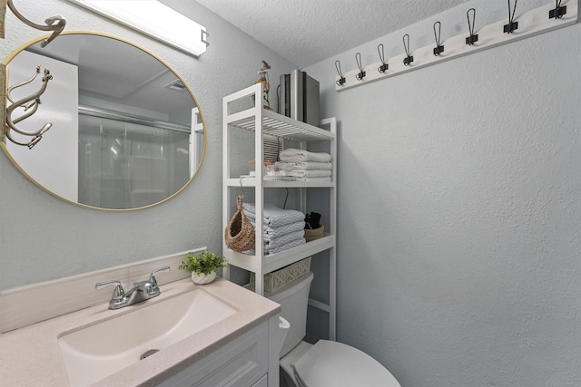 full bathroom with a textured ceiling, a textured wall, toilet, vanity, and an enclosed shower