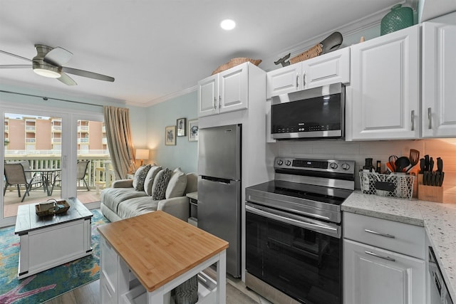 kitchen featuring stainless steel appliances, ornamental molding, white cabinetry, and light stone counters