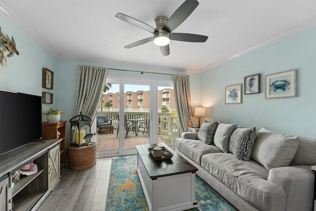 living area with light wood-style flooring, ornamental molding, and a ceiling fan