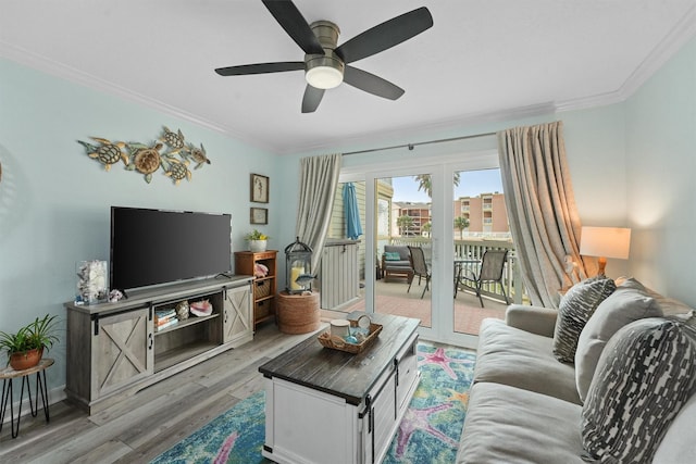 living area with ceiling fan, light wood-type flooring, baseboards, and crown molding