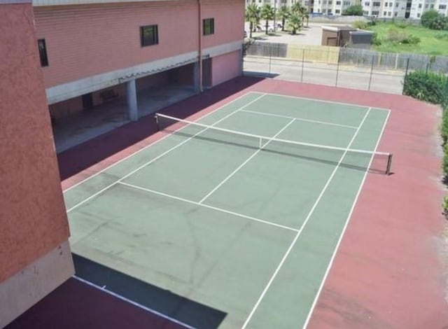 view of tennis court featuring fence