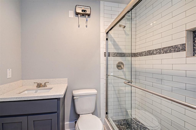 bathroom featuring vanity, a shower with door, and toilet