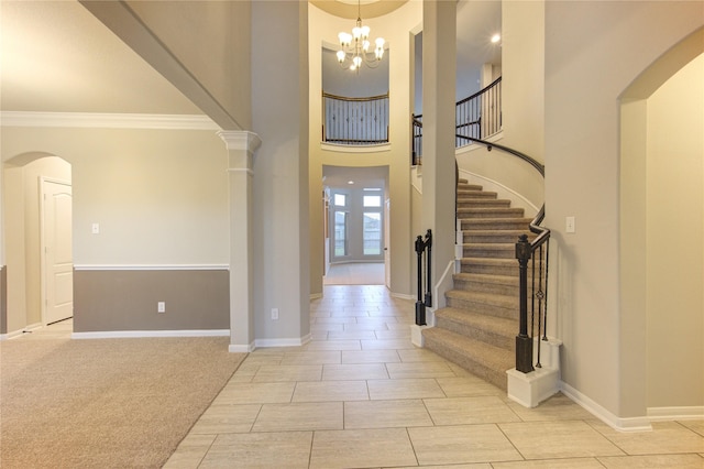 foyer entrance featuring a chandelier, stairway, light carpet, and baseboards