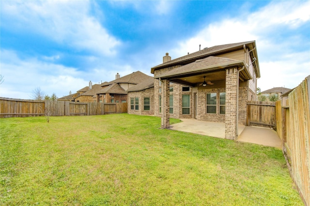 rear view of property with brick siding, a lawn, a patio, and ceiling fan