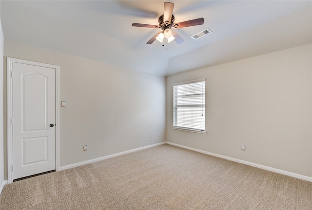 empty room with lofted ceiling, light carpet, baseboards, and visible vents