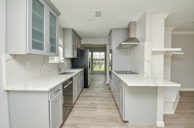 kitchen featuring visible vents, gray cabinets, stainless steel dishwasher, black electric stovetop, and wall chimney exhaust hood