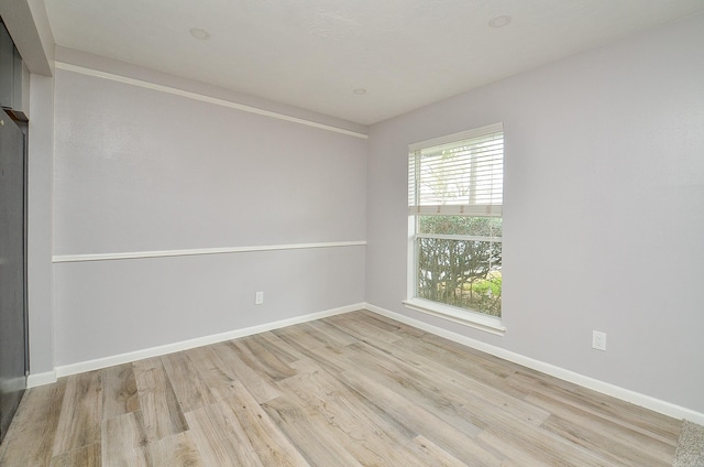 unfurnished room featuring baseboards and wood finished floors