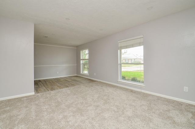 spare room with baseboards and carpet