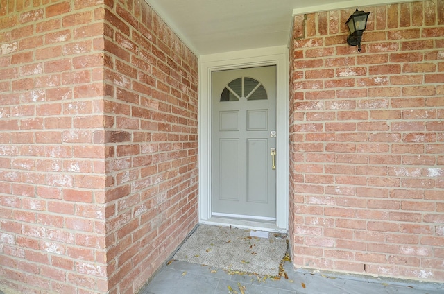 property entrance featuring brick siding