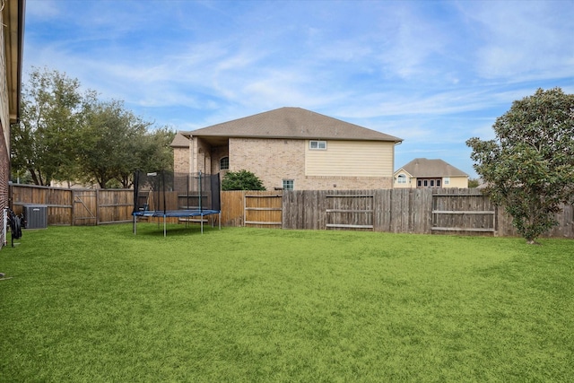 view of yard with a fenced backyard, a trampoline, and cooling unit