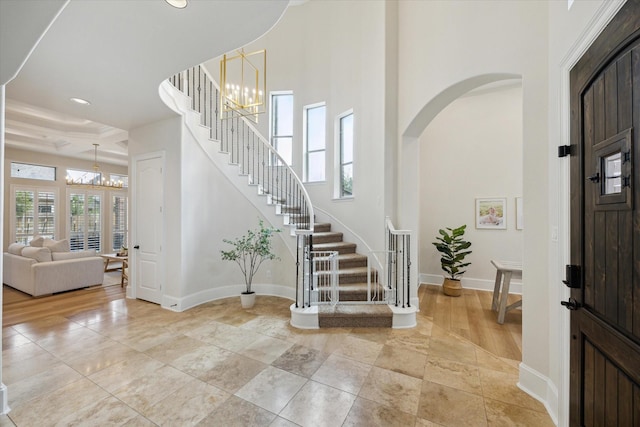 foyer with a chandelier, stairway, and baseboards