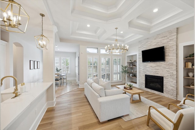 living area featuring a chandelier, light wood-style floors, and built in shelves