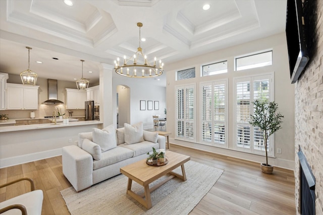 living room with light wood finished floors, arched walkways, coffered ceiling, and a stone fireplace