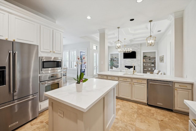 kitchen featuring appliances with stainless steel finishes, open floor plan, a center island, built in shelves, and recessed lighting