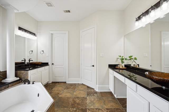 full bathroom featuring a garden tub, ornate columns, visible vents, vanity, and baseboards