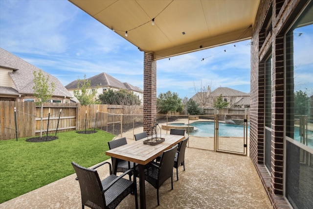 view of patio featuring outdoor dining space, a pool with connected hot tub, and a fenced backyard