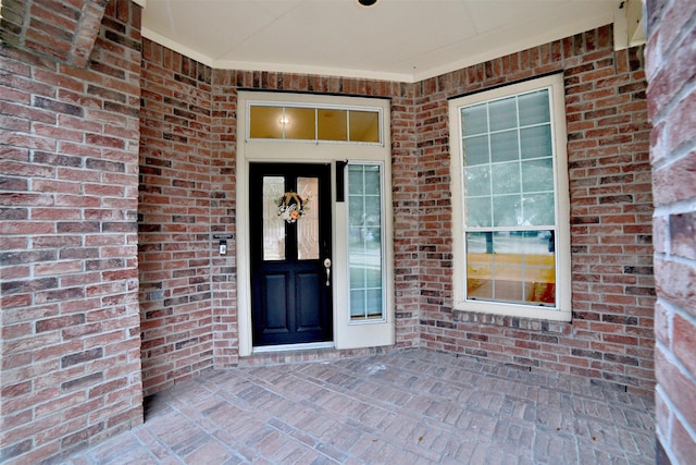 view of exterior entry featuring brick siding