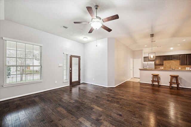 unfurnished living room featuring dark wood finished floors, baseboards, and ceiling fan