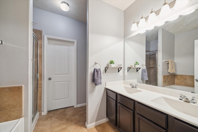 bathroom with a garden tub, a shower stall, tile patterned flooring, and a sink