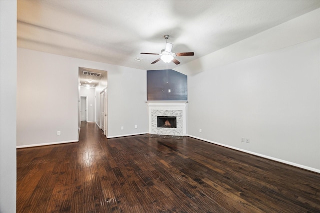 unfurnished living room with lofted ceiling, dark wood-type flooring, a fireplace, visible vents, and baseboards