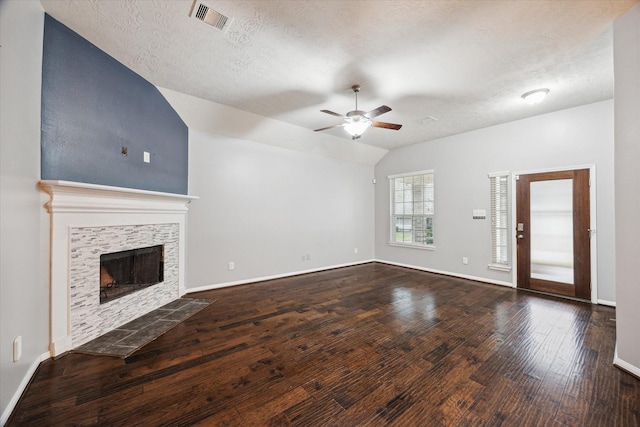 unfurnished living room with visible vents, a ceiling fan, lofted ceiling, dark wood-style floors, and a fireplace