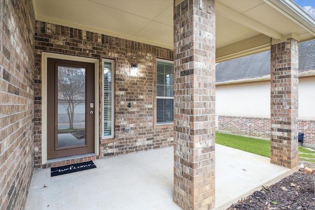 view of exterior entry featuring brick siding