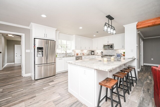 kitchen featuring light stone countertops, white cabinetry, and appliances with stainless steel finishes