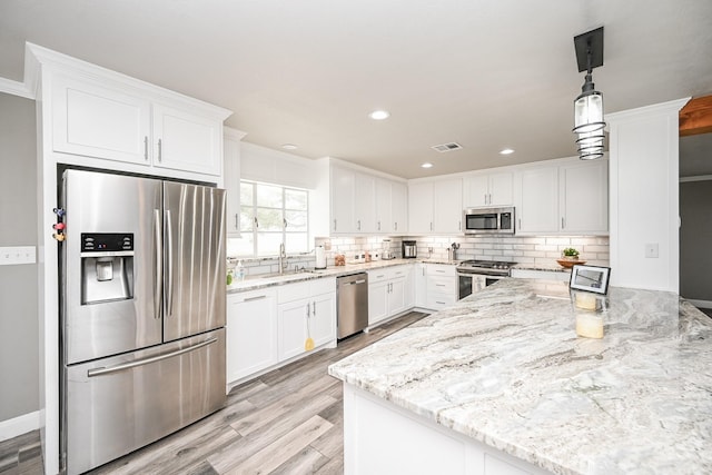1133 Peebles St, Hempstead, TX 77445 - kitchen with stainless steel appliances, white cabinets, tasteful backsplash, light stone counters, and recessed lighting