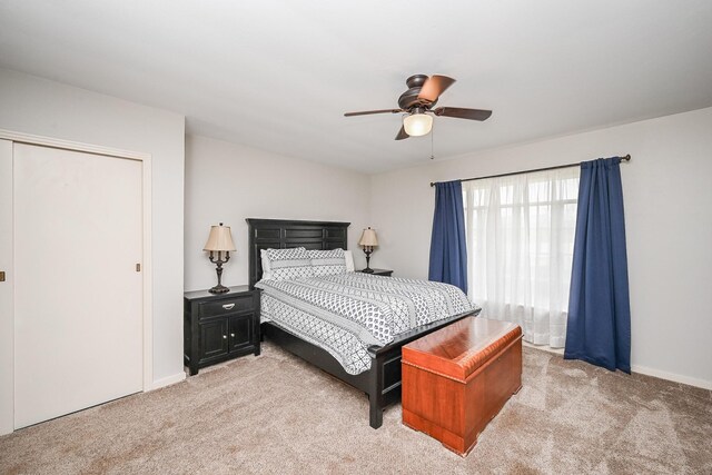 bedroom with baseboards, ceiling fan, and light colored carpet