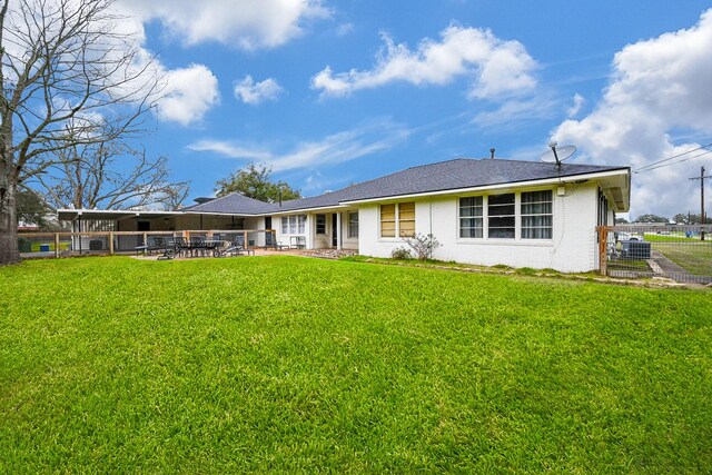 back of house with a patio area, brick siding, a lawn, and fence