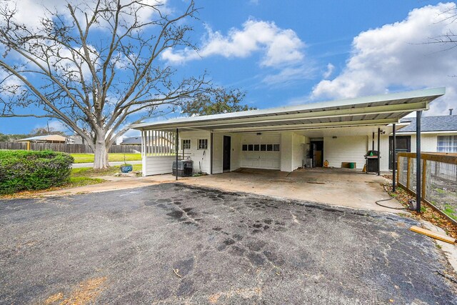 garage featuring aphalt driveway and fence