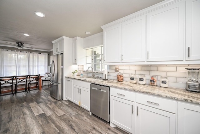 1133 Peebles St, Hempstead, TX 77445 - kitchen featuring stainless steel appliances, a sink, recessed lighting, decorative backsplash, and white cabinets