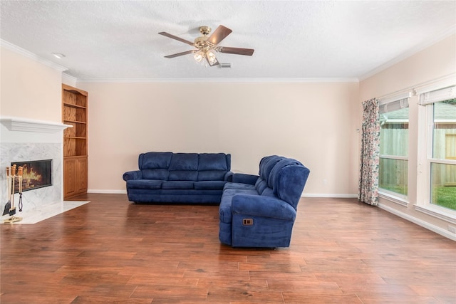 living room with hardwood / wood-style flooring, a premium fireplace, and a textured ceiling