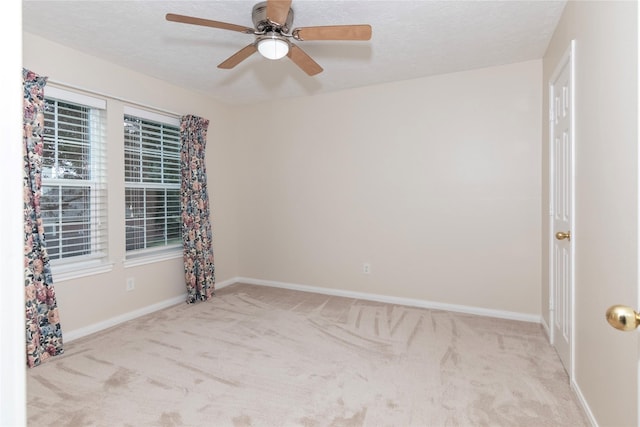 unfurnished room with a textured ceiling, light carpet, and ceiling fan