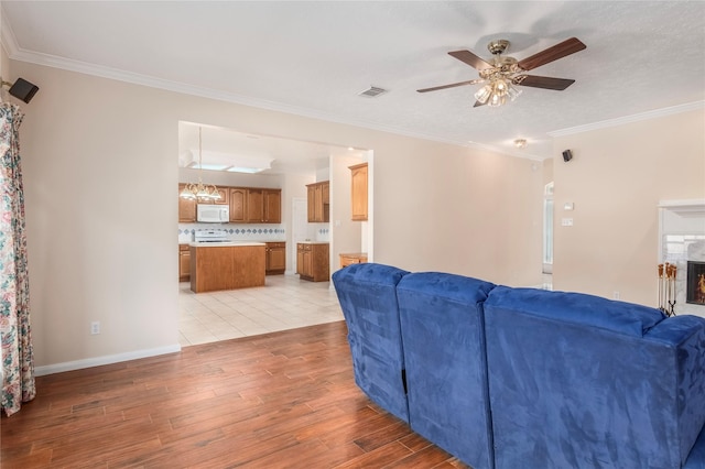 living room featuring ceiling fan, ornamental molding, and light hardwood / wood-style floors