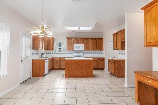 kitchen with white appliances, pendant lighting, a center island, backsplash, and an inviting chandelier