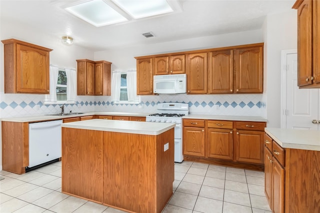 kitchen featuring light tile patterned floors, white appliances, decorative backsplash, a kitchen island, and sink