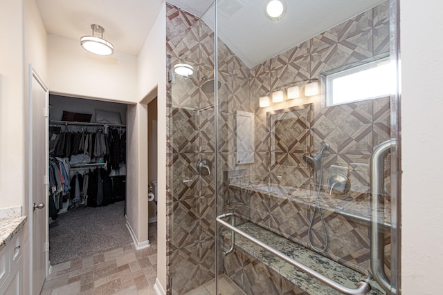full bath with a shower stall, vanity, a spacious closet, and toilet